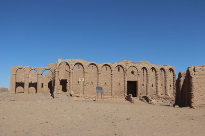 Castle on desert against clear blue sky