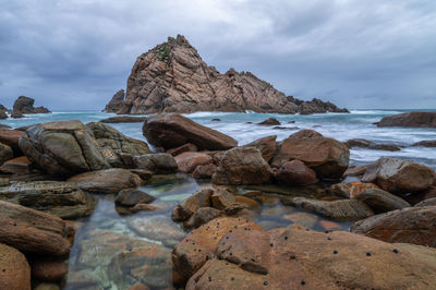 Rocks on beach against sky