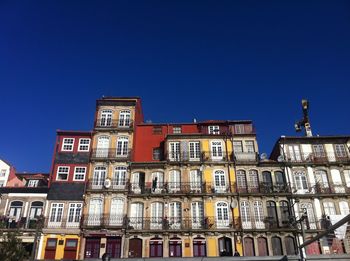 Low angle view of buildings against clear blue sky