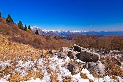 Scenic view of snowcapped mountains against blue sky