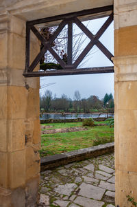 Bridge over canal by old building against sky