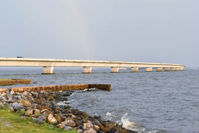 Bridge over sea against clear sky