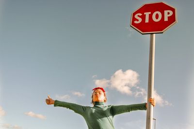 Low angle view of road sign against sky