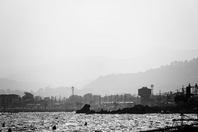 Buildings by sea against sky in city