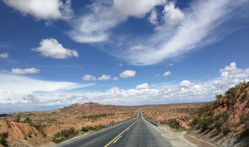 Road passing through landscape against sky