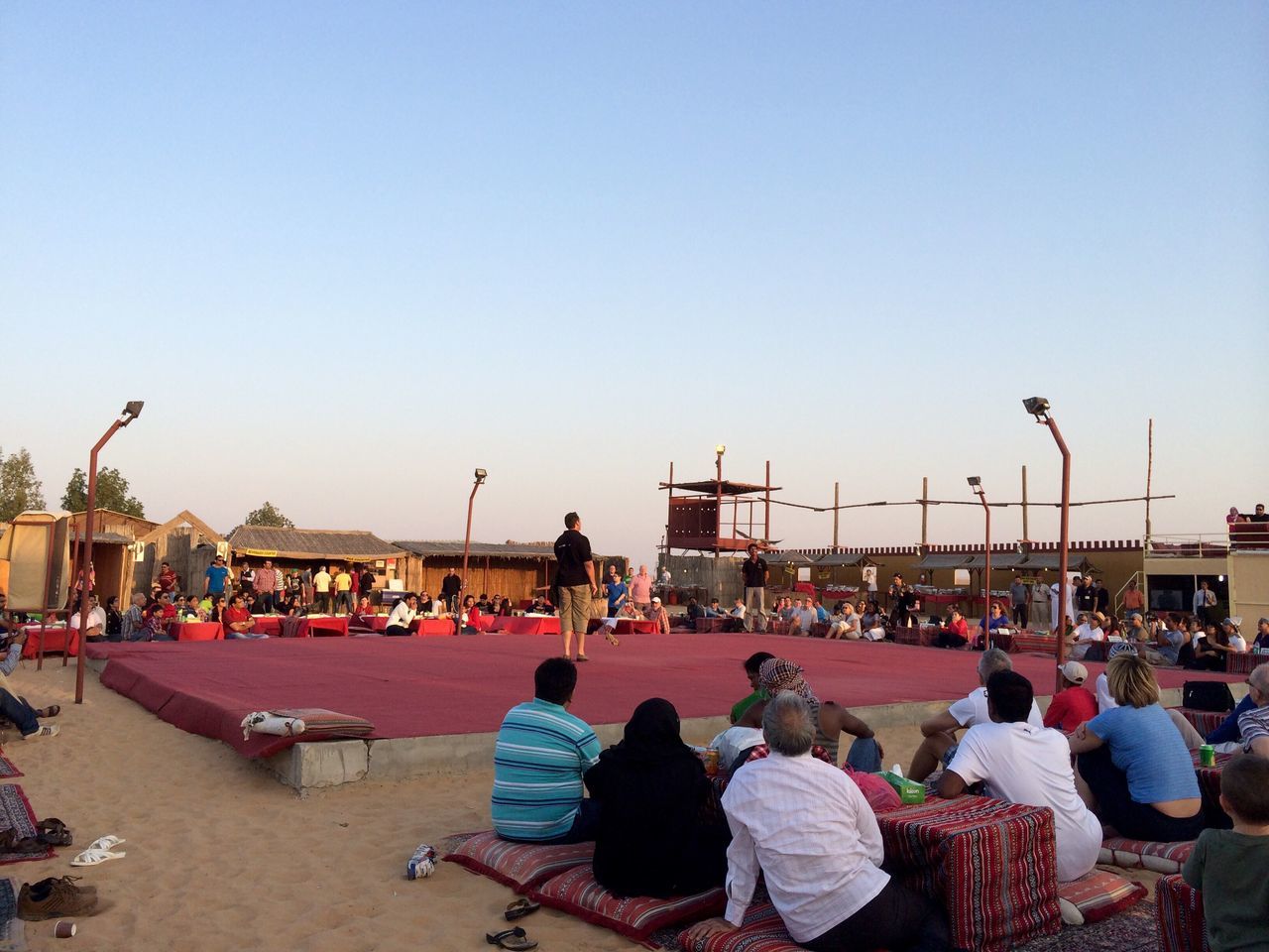 clear sky, large group of people, copy space, men, person, lifestyles, leisure activity, mixed age range, built structure, beach, outdoors, transportation, group of people, sky, day, architecture, sitting, crowd, medium group of people