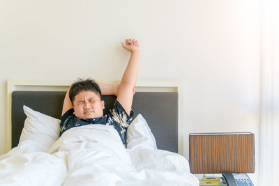 Portrait of boy lying on bed at home