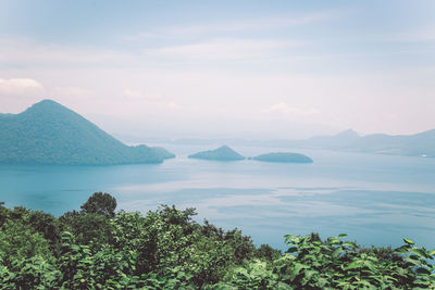 Scenic view of sea and mountains against sky