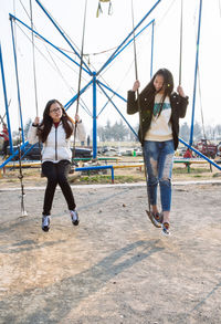 Young woman playing on swing in playground