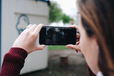 Midsection of woman photographing with mobile phone