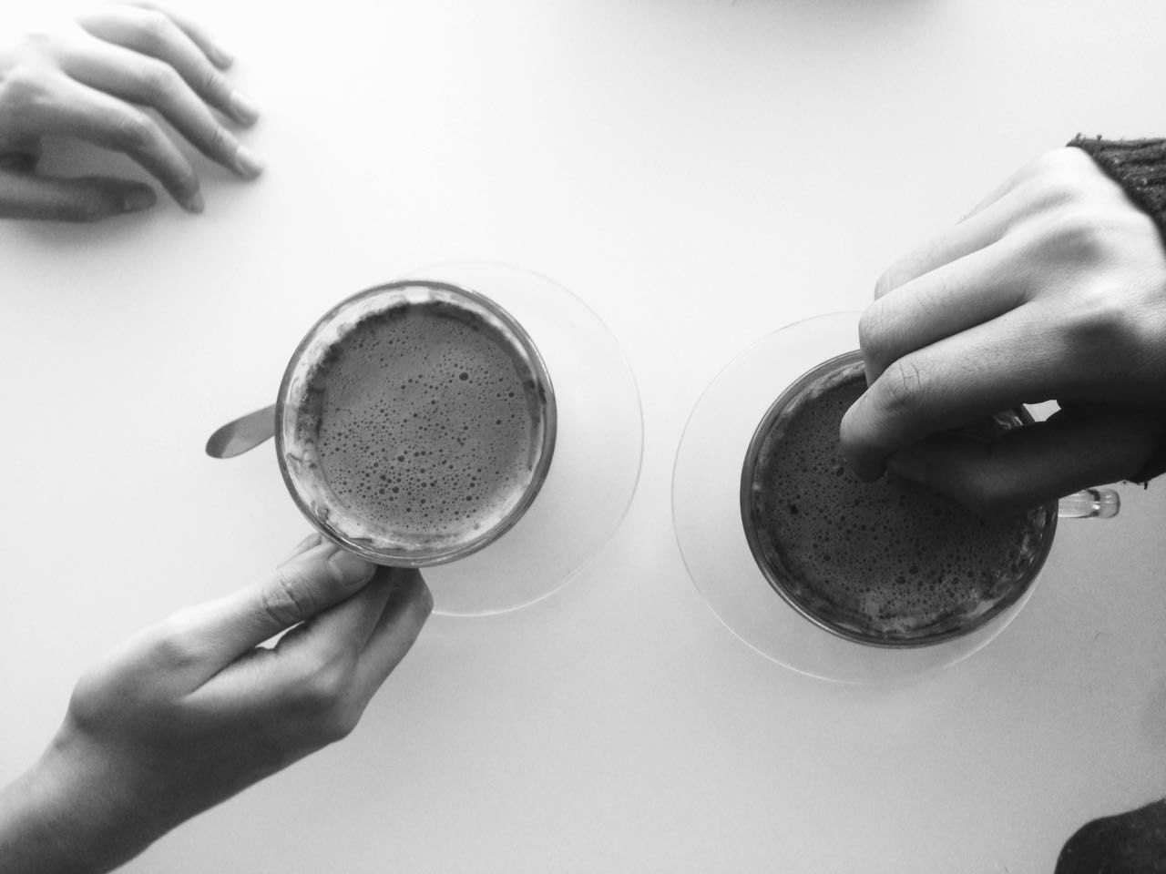 CLOSE-UP OF HAND HOLDING COFFEE CUP WITH CAFE