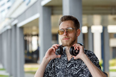 Portrait of young man wearing sunglasses standing outdoors