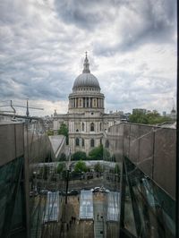 Buildings in city against cloudy sky