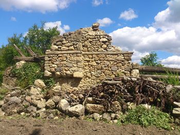 Old ruins on field against sky