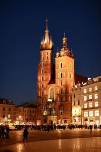 Group of people in front of building at night cracow poland 