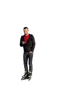 Portrait of young man standing against white background