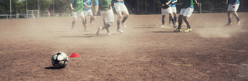 Low section of people playing soccer ball