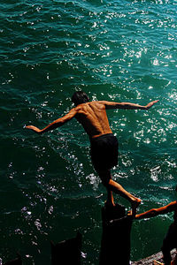 Rear view of woman swimming in sea