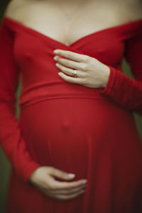 Midsection of woman holding heart shape