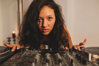 Close-up of fashionable young woman playing music at home