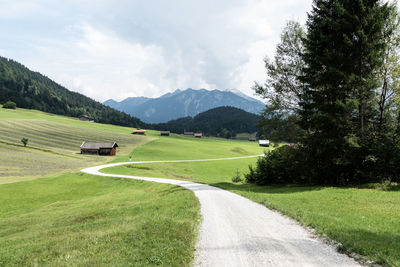 Road amidst field against sky