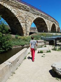 Rear view of man walking on bridge