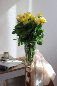  beautiful flowers in vase on table cozy against the wall.