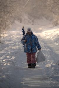 Rear view of man walking in water