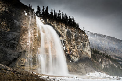 Scenic view of waterfall against sky