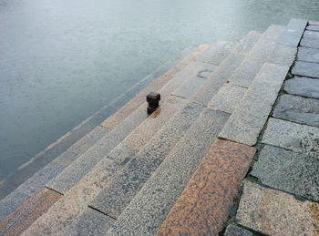 High angle view of wet steps leading towards lake