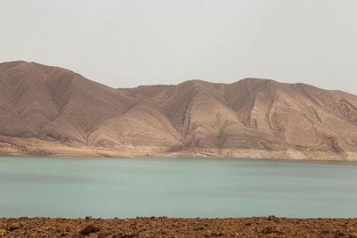 Scenic view of lake and mountains against clear sky