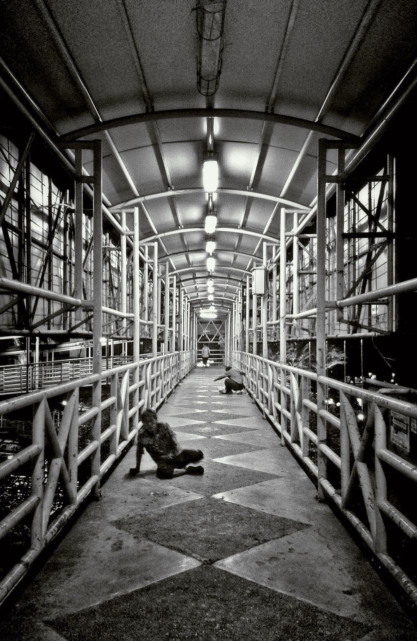 indoors, ceiling, the way forward, lighting equipment, illuminated, architecture, diminishing perspective, built structure, corridor, in a row, empty, vanishing point, railing, incidental people, interior, flooring, absence, tiled floor, electric light, hanging