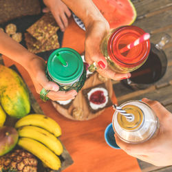 Cropped image of people holding drinks