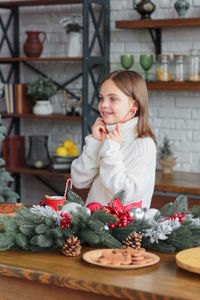 Cute smiling little child girl eating chocolate biscuits and drinking hot cocoa