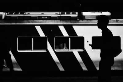 Man walking against train on railroad station