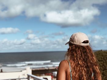 Rear view of woman looking at sea against sky