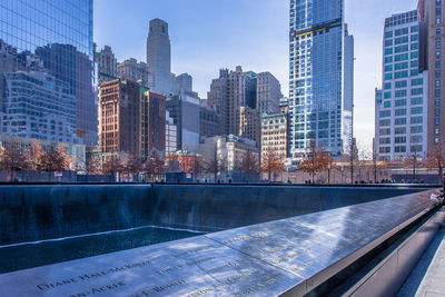 City at waterfront against cloudy sky