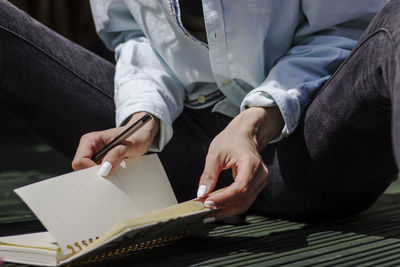 Midsection of man reading book