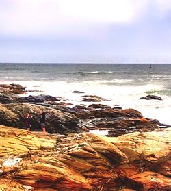 Scenic view of rocky beach against sky