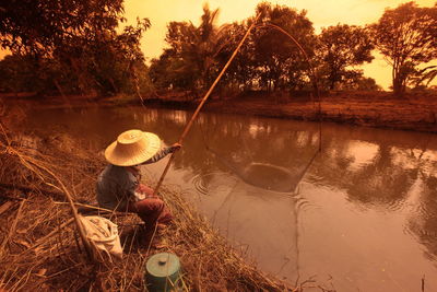 Man fishing in lake at forest