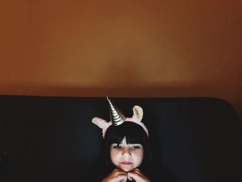 Close-up of cute thoughtful girl wearing headband at home