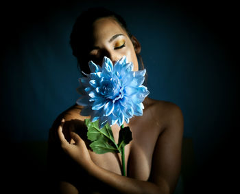 Beautiful young woman against blue background