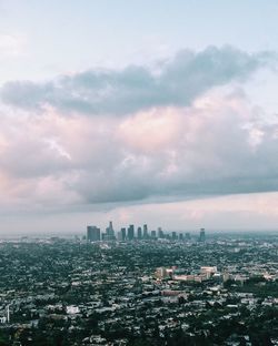 Cityscape against cloudy sky during sunset