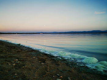 Scenic view of beach against sky during sunset