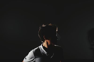 Man wearing mask against black background