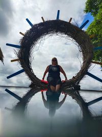 Full length portrait of woman standing against sky