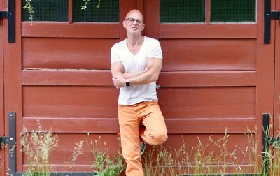 Portrait of woman standing against brick wall