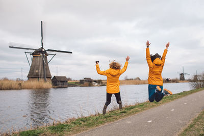 Rear view of women with umbrella against sky