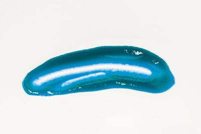 Close-up of blue paint over white background