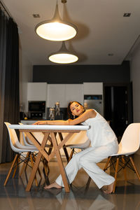Young woman sitting on chair at home